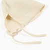 Cotton knitted cap with straps for newborns, light beige